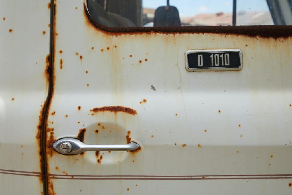 An old, rusty truck with a visible number plate, showcasing its weathered exterior and vintage charm.