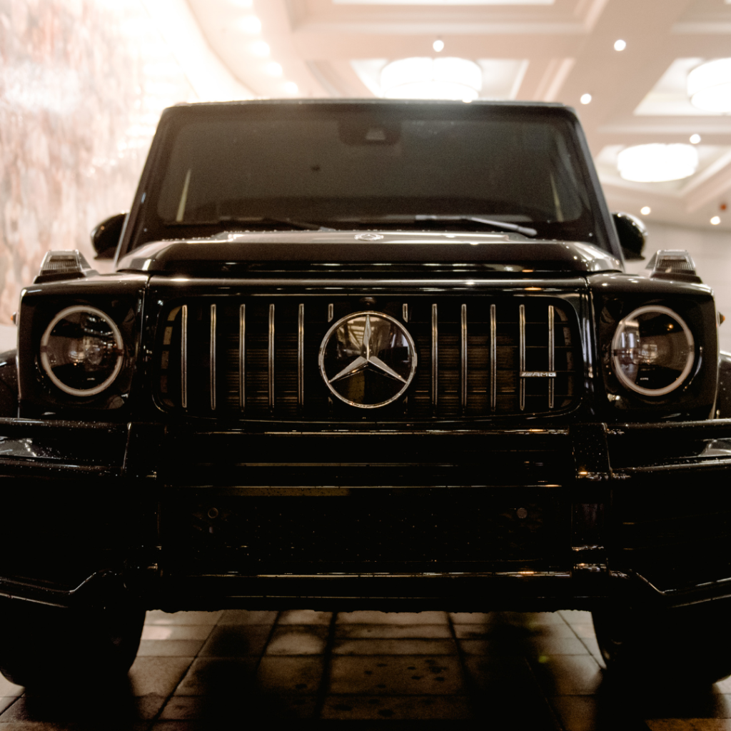 A black Mercedes G-Class parked elegantly in a spacious room, showcasing its luxury and design.
