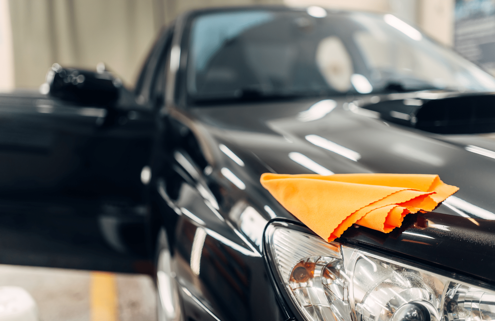 A car parked with a towel draped over its hood, showcasing a casual and relaxed atmosphere.