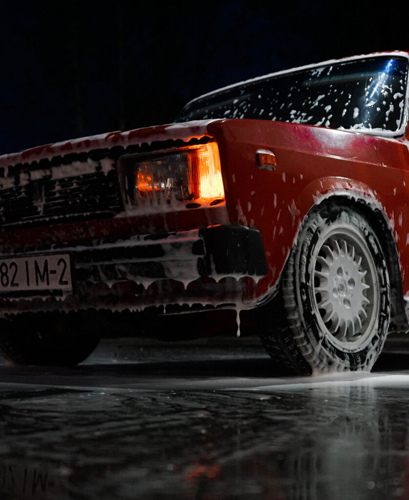 A car completely covered in a thick layer of snow and ice, showcasing the harsh winter conditions.