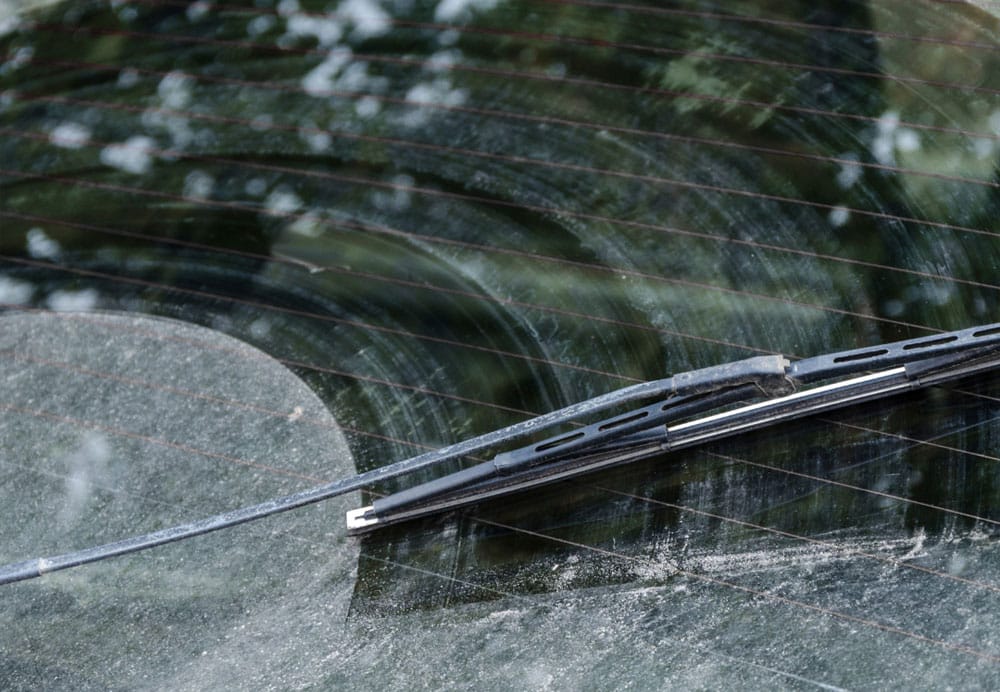 A close-up of a car windshield wiper featuring a broken blade, highlighting the need for replacement or repair.